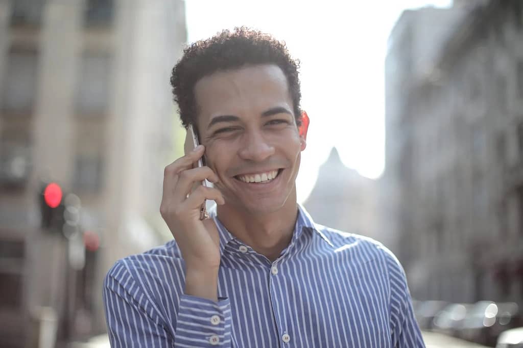 homme vêtu d'une chemise rayée qui discute au téléphone