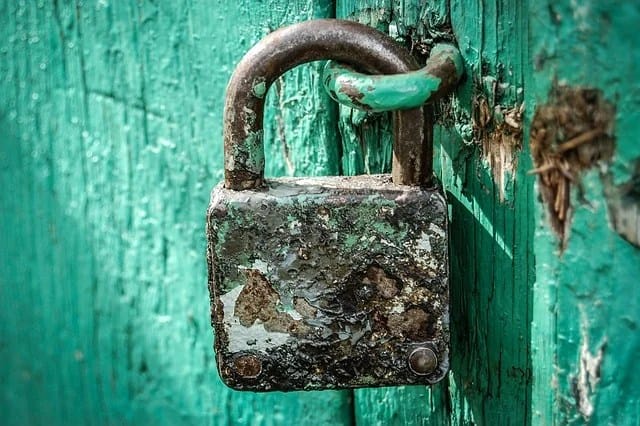 Cadenas rouillé en fer fermant une vieille porte en bois, telle la clé de l'énigme généalogique